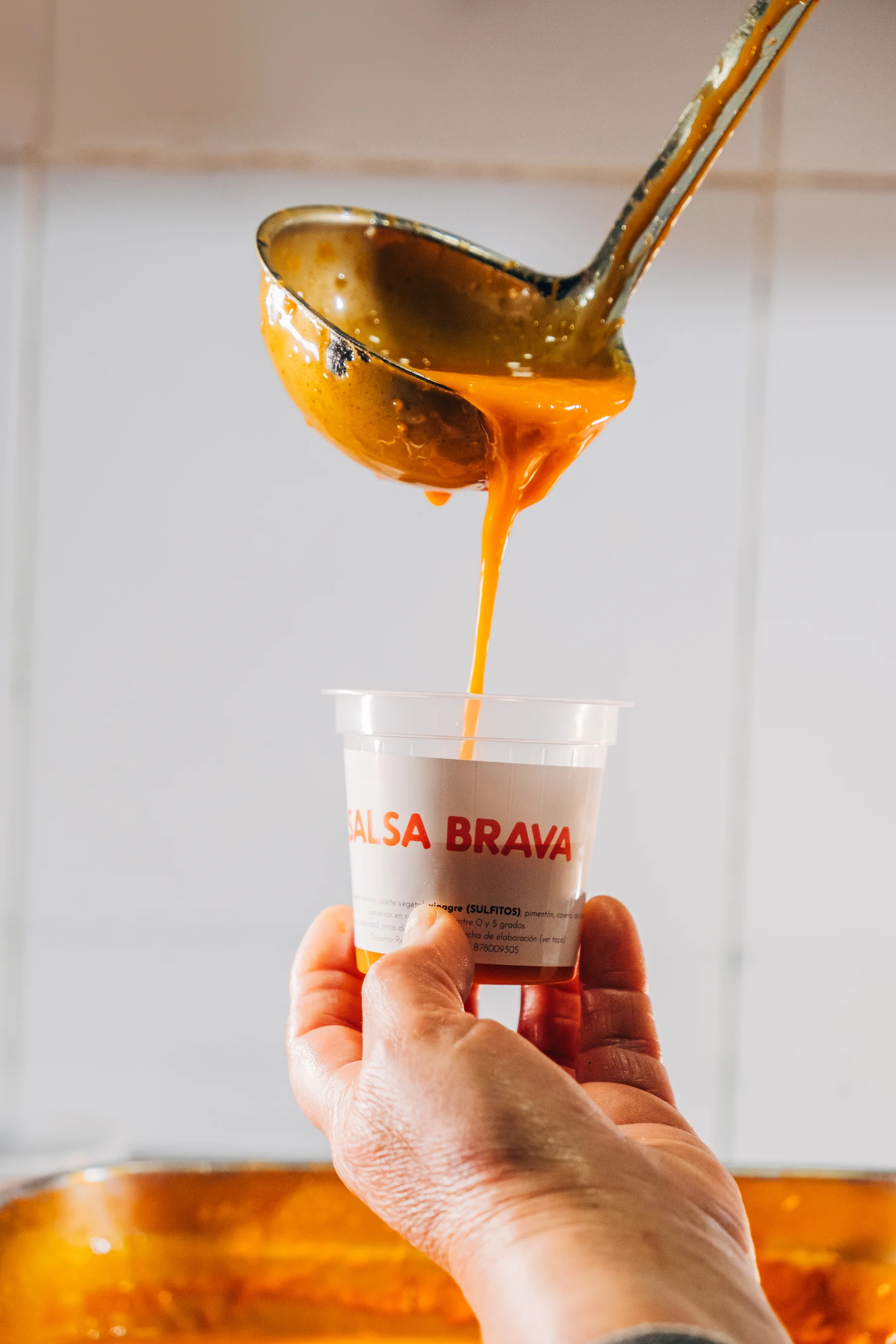 Salsa brava de Docamar recién elaborada, servida con un cucharón