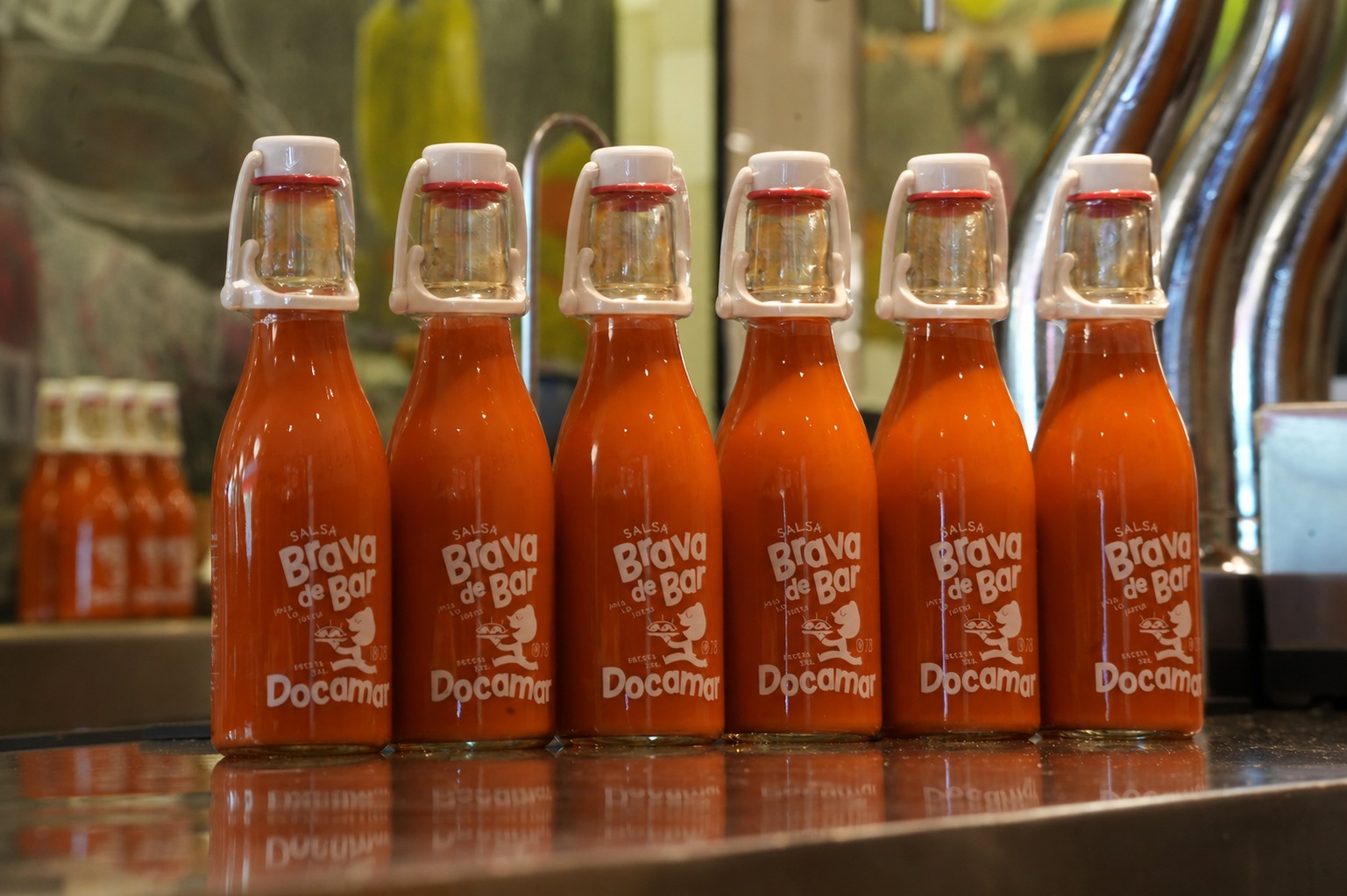 Botellas de Salsa Brava de Bar Docamar alineadas sobre la barra